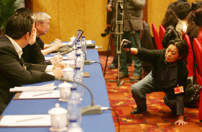 倪萍客串记者跪地为冯小刚等其他委员拍照。