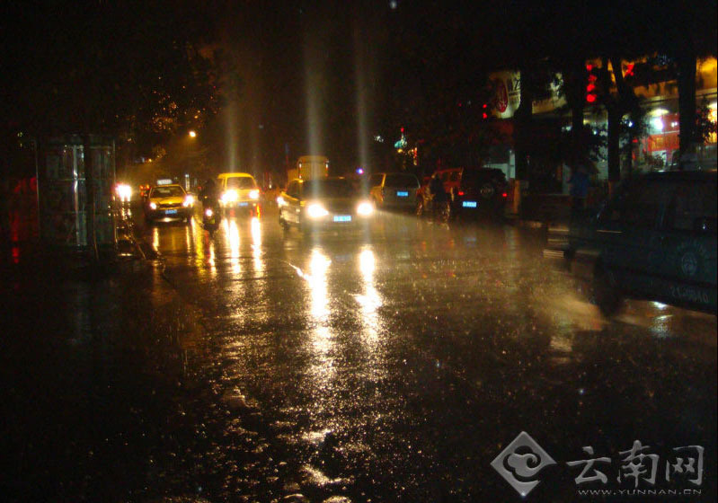27日晚，昆明终于迎来一场久违的降雨，汽车驶过路面时带起一片水雾。记者 赵岗 摄