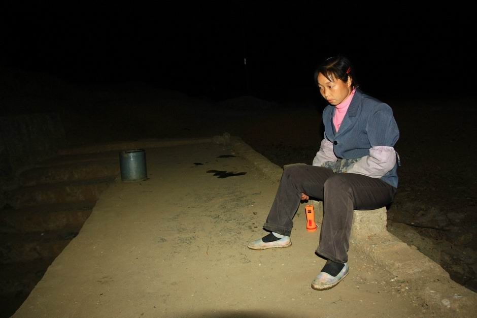 妻子刘春香坐在井边等丈夫回来。