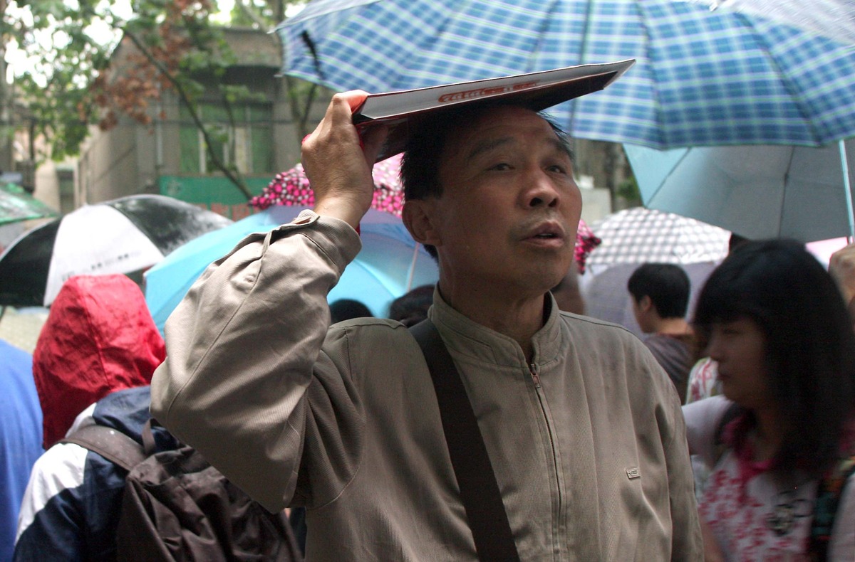 家长雨中翘首以盼,等待孩子走出考场.(梁萌摄)