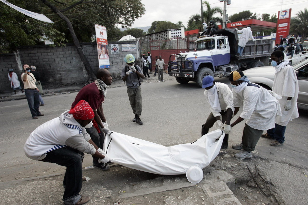 北京时间2010年1月15日，海地首都太子港大街上被白布遮盖的尸体随处可见。一些志愿者将遇难者用白布包裹起来。