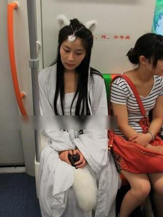 白狐少女频现上海地铁 穿白长裙拖长尾
