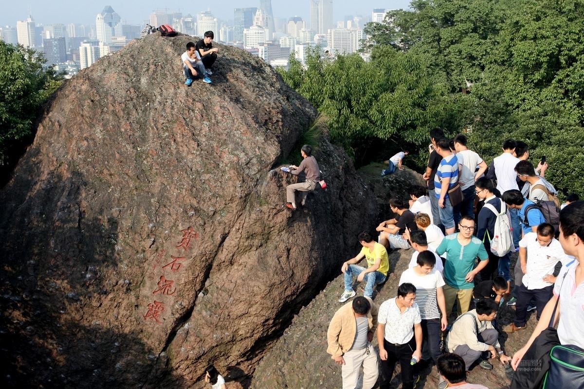 杭州宝石山人潮拥挤 游客带小孩爬山崖抄近道