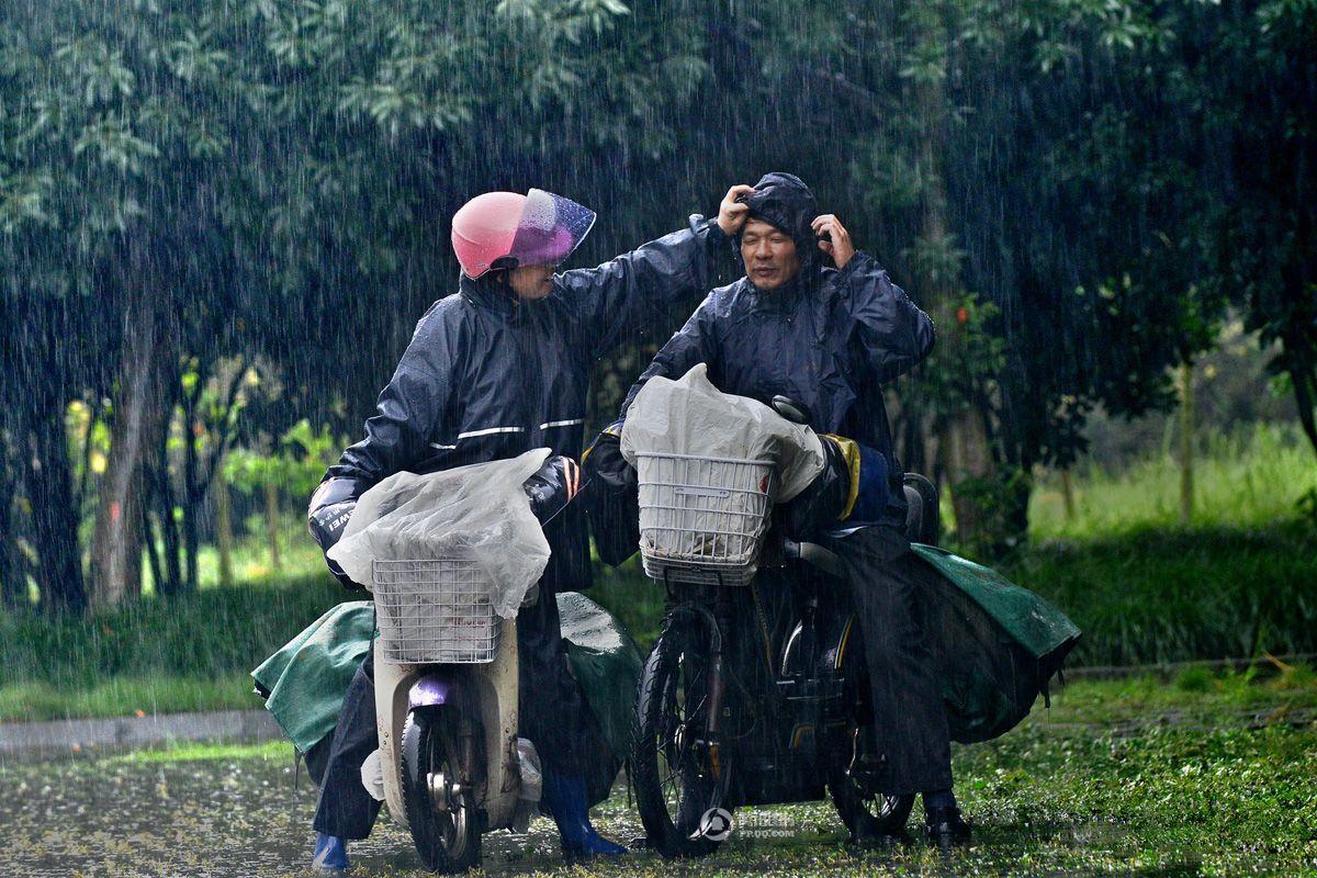 风雨中,赵龙珍帮丈夫戴上被风吹掉的雨帽,送报路上他们风雨同舟,一起