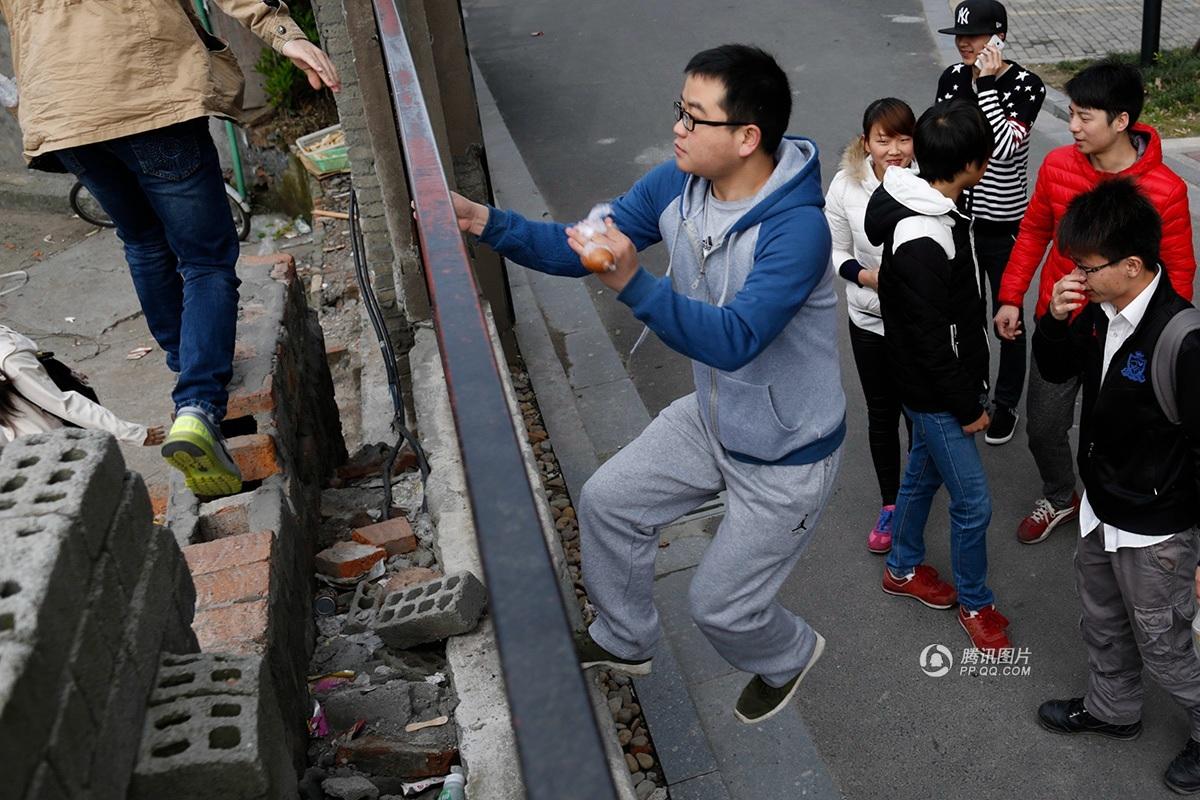 【组图】杭州一小区居民每天翻墙出入 早高峰需排队