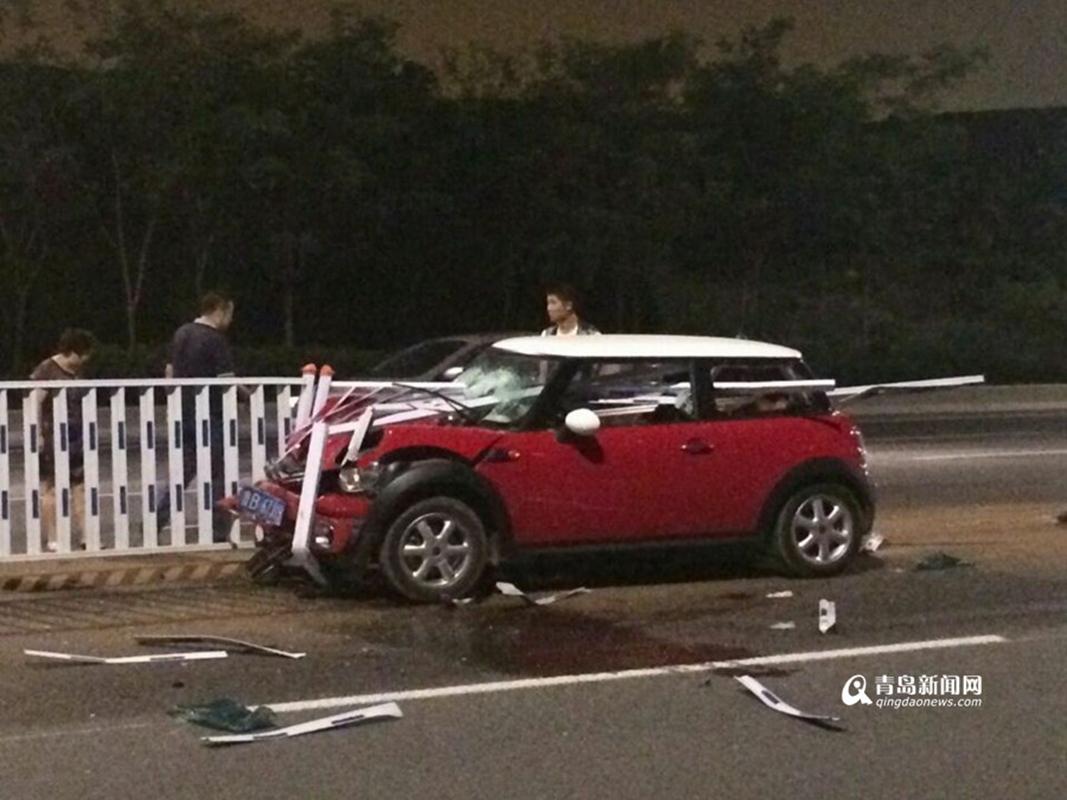 宝马mini汽车,由东向西行驶,撞向道路中间护栏,受伤司机已被送高清图片