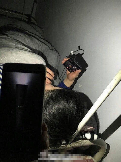 组图:男生宿舍熄灯与女友视频 室友为其照明
