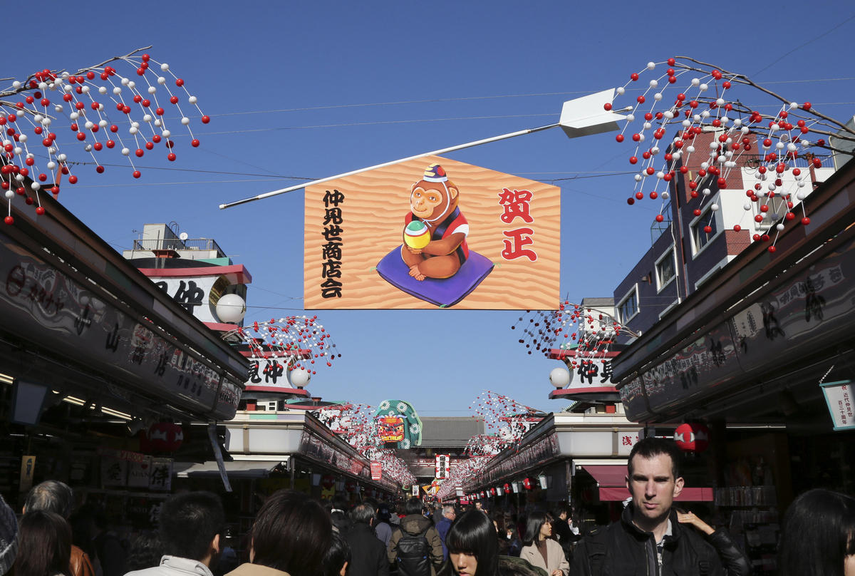 12月26日,日本东京浅草寺前的仲见世步行街上悬挂着金猴图案,迎接即将