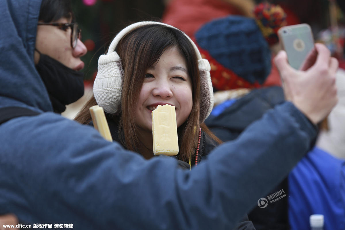 哈尔滨气温降至零下30度 街头吃冰棍成一景