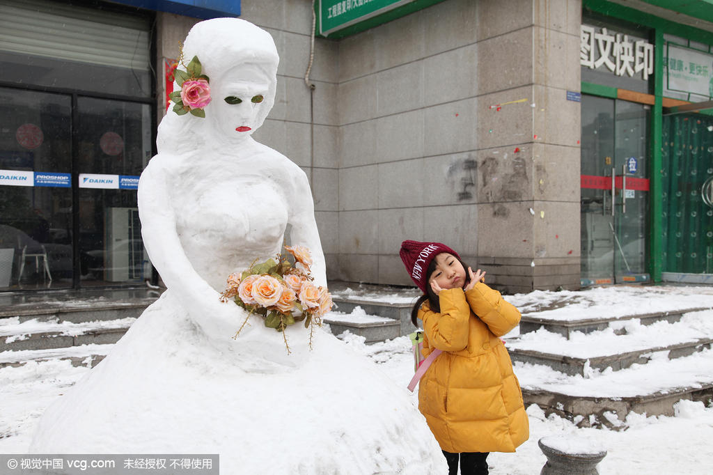 西安现雪人"性感新娘" 吸引路人合影