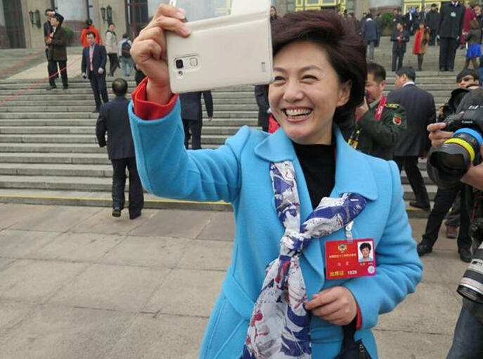 央视主播海霞人民大会堂前玩自拍 媒体争相拍照