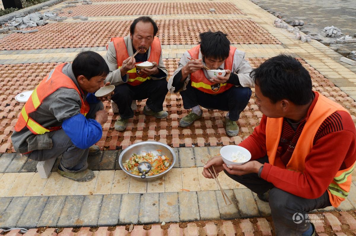 劳动者的午餐:2012年11月13日,贵州省凯里市,建筑工地上的农民工围着