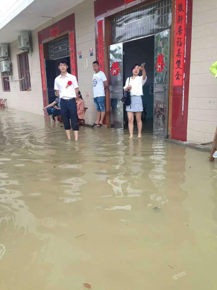 湖北新人暴雨中办婚礼 亲友漫脚积水中吃酒席(图)