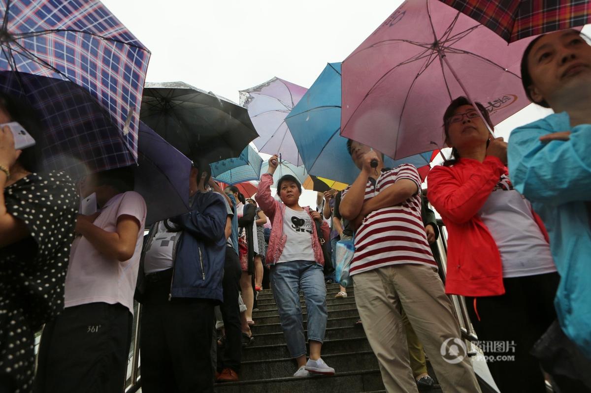 郑州上百家长候考 撑起“雨伞阵”场面壮观(组图)