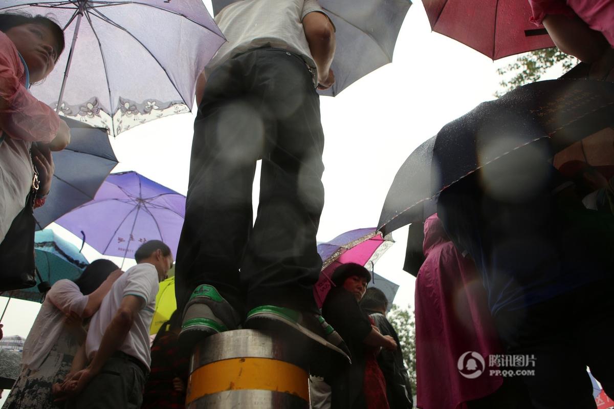 郑州上百家长候考 撑起“雨伞阵”场面壮观(组图)