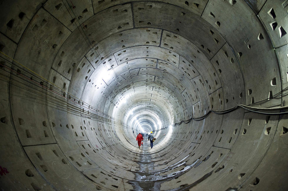 2015年10月11日,两名中国工人走在湖南长沙地铁隧道的修建施工现场.