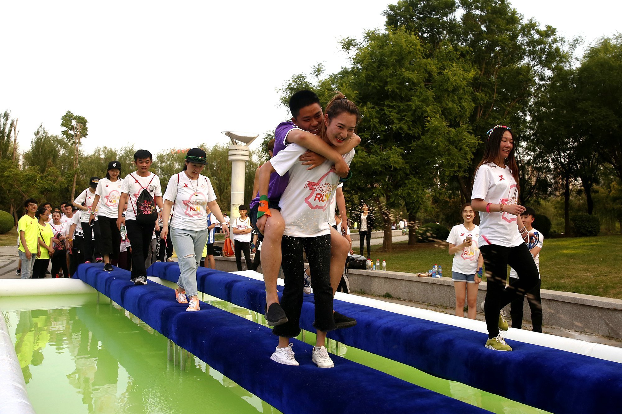 特步企鹅跑女背男过独木桥