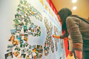 志愿者们用数百张笑脸照片组成EXPO展板(图