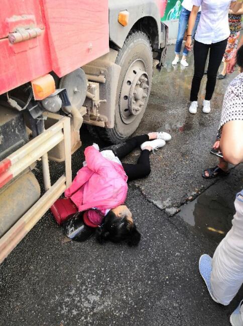 荆州发生一起车祸 一名妇女被压在渣土车车底