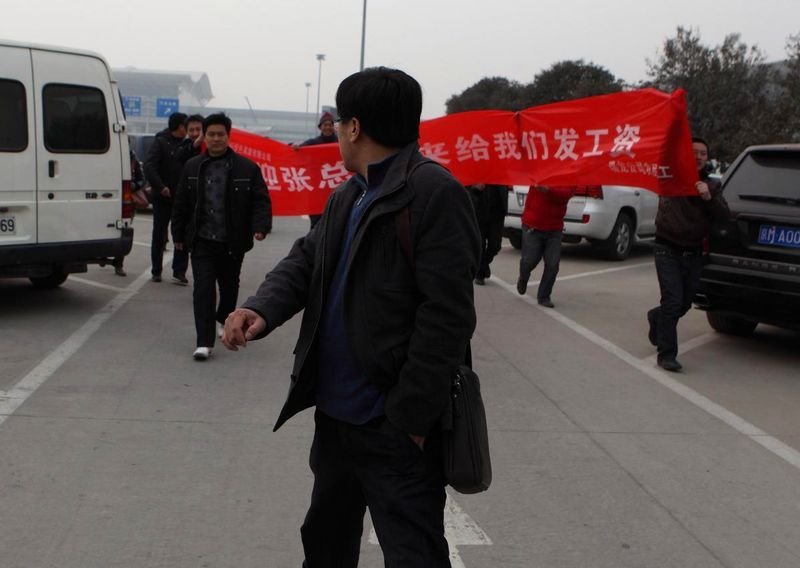 西安农民工手捧鲜花拉欢迎领导横幅讨薪