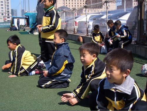 组图:大连市长杯足球赛 小球员看书手捧足球