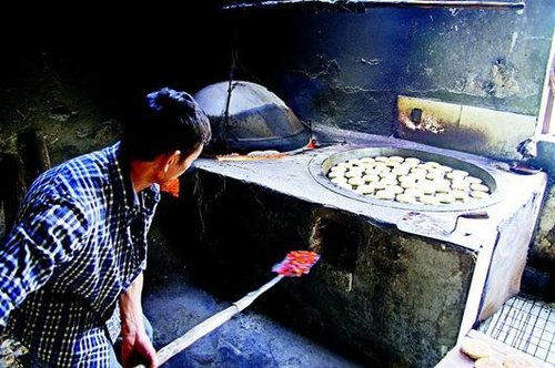 图为:手工制作月饼都是用柴火进行烘烤.