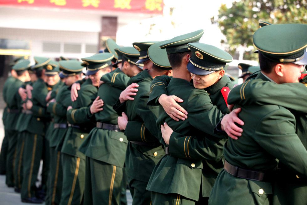 11月24日,武警安徽省总队亳州支队直属中队退伍老兵与现役兵士相拥