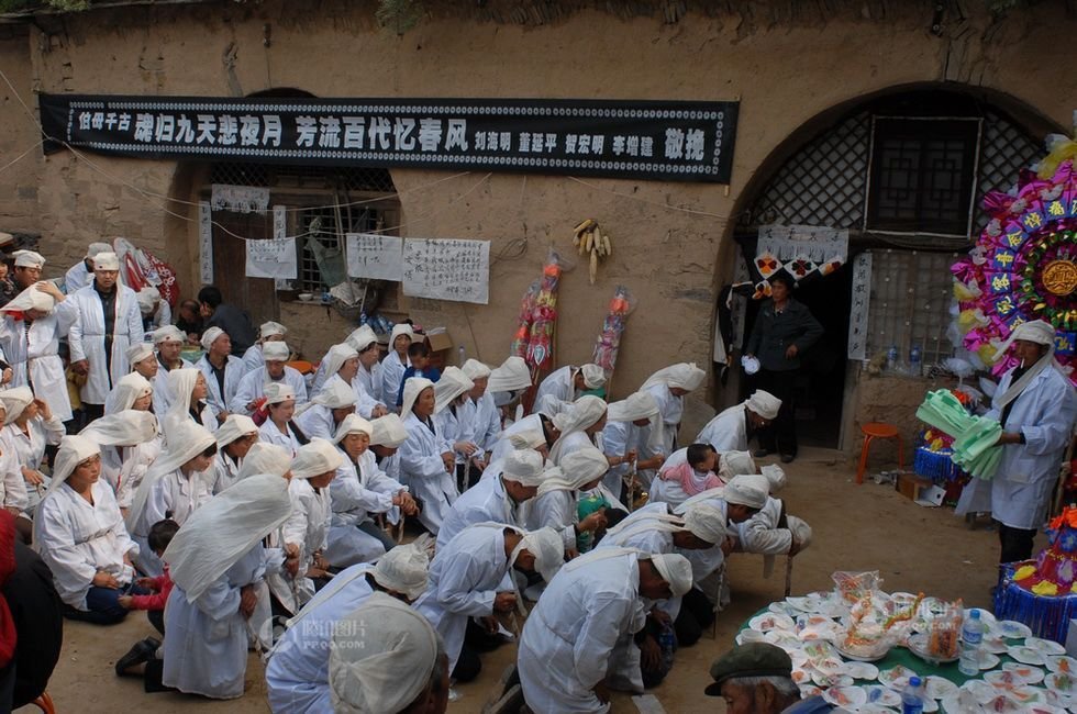 进入院子,依辈份年龄有序地排列着双膝跪地,深沉悲哀地磕头.