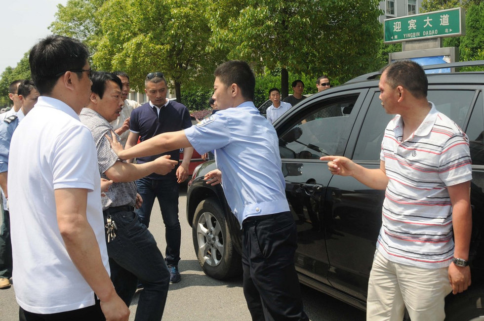肇事司机黎某躲在民警身后,脸上被打的鼻青眼肿