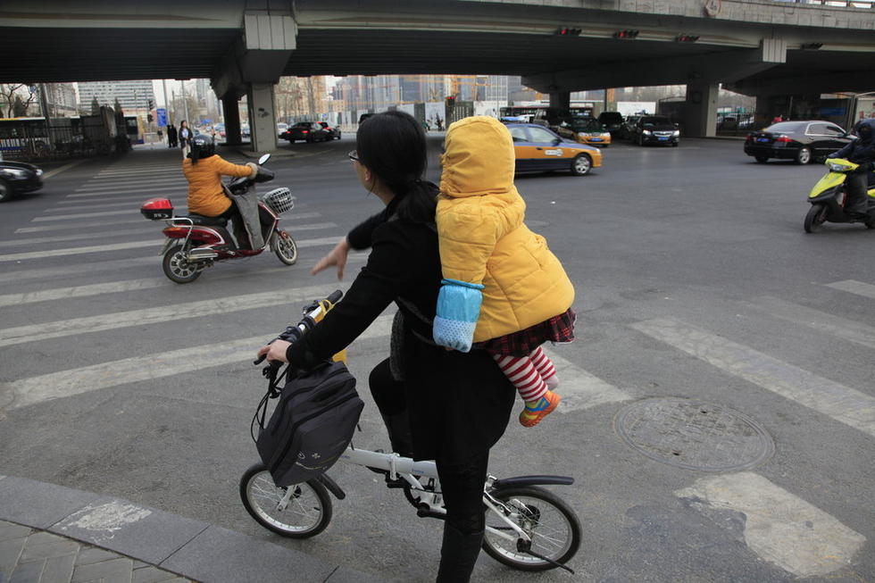 北京妈妈骑车背孩子飞驰 吓坏路人