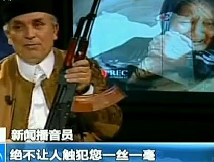 利比亚播音员持AK-47誓言保护卡扎菲