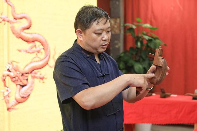 非遗传承人刘更生在公开课上,讲解木质家具的榫卯结构.