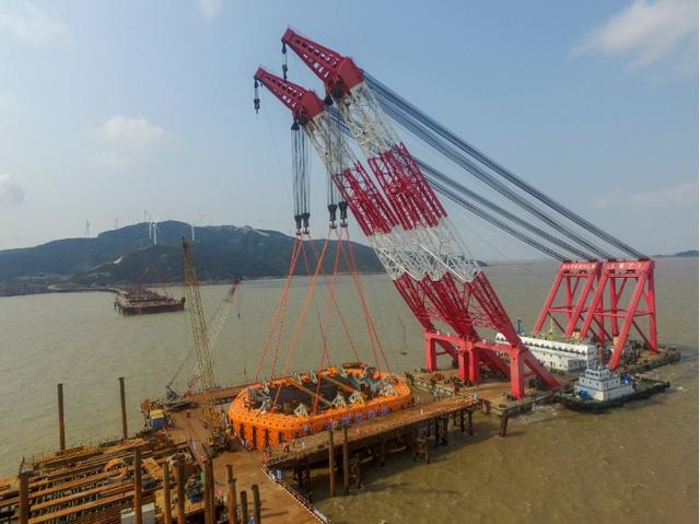 中国建筑最大钢套箱成功下放 宁波舟山港主通道位于浙江省舟山群岛中部,连接富翅岛、舟山本岛、长白岛、岱山岛、鱼山岛等5座岛屿,全长36.777公里,按双向四车道高速公路标准设计,计划于2021年全线建成。建成后将同甬舟高速相连接,使舟山连岛工程总建设里程达86.68公里,跨越八个岛屿,拥有十座大桥,成为世界最长的连岛高速公路和世界规模最大的跨海桥梁群。舟山港是浙江省重要的港口,是连接21世纪海上丝绸之路的重要渠道和门户,舟山港主通道的建成将紧密联系海上丝绸之路沿线各国,进一步提升浙江经济发展。