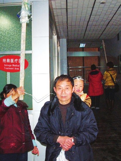 遂宁中心医院床位紧张 市民举根棍子站着输液