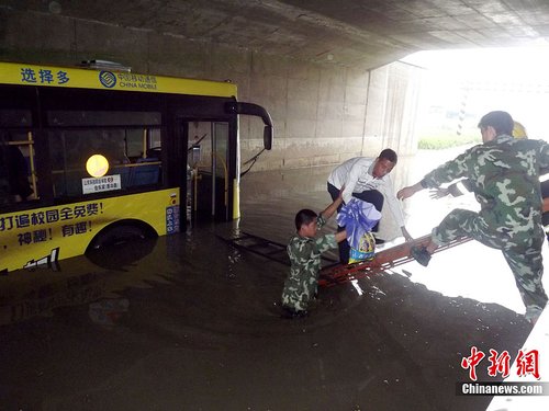 山东潍坊持续阴雨天气 公交车被困积水中