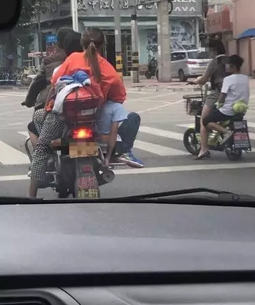 近日,一组摩托车上搭载4人,其中一人竟然坐在脚踏板上的照片,引起