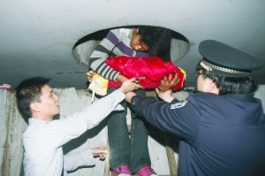 小涛将自己的孩子从洞口抱出.本报记者 邓建鹰 摄