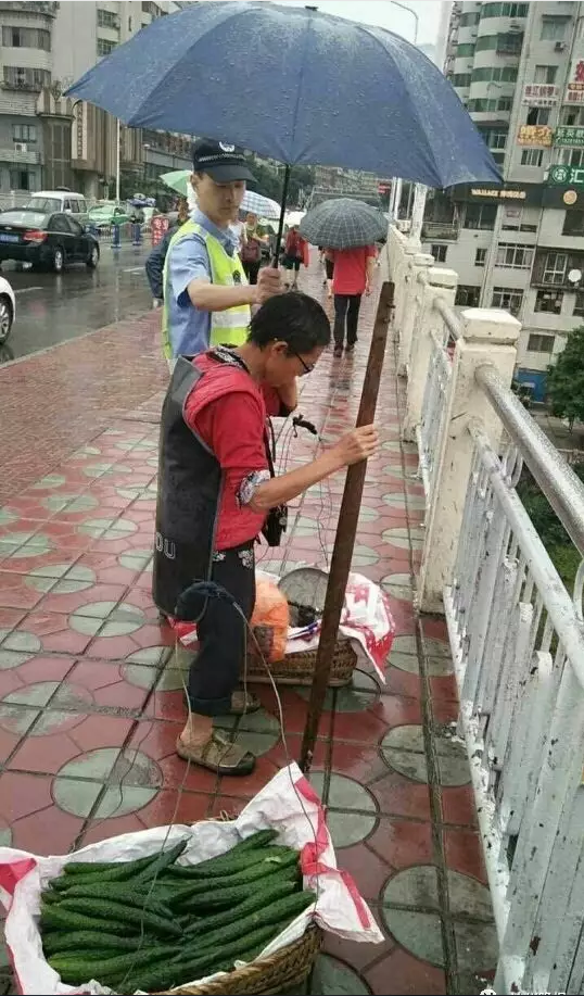 路遇太婆雨天挑担赶路 达州城管为卖菜婆婆撑