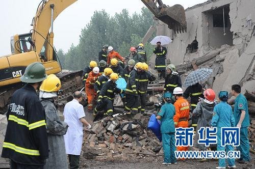 7月8日11时48分，救援人员在现场一个倒塌的两层楼下搜救出一名遇难者。新华社记者 赵鹏 摄