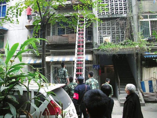 短裤男站雨篷向楼下扔瓶子 消防搭梯救人