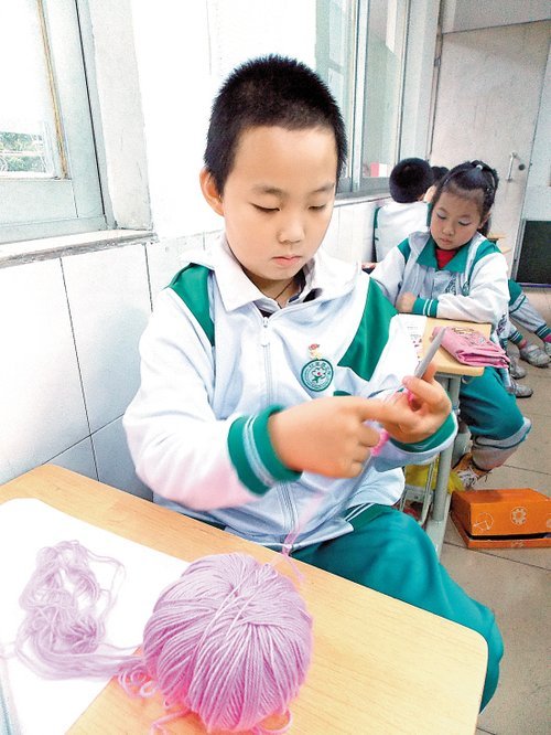 兴趣班小学生为爸妈织毛衣 培养注意力及耐心