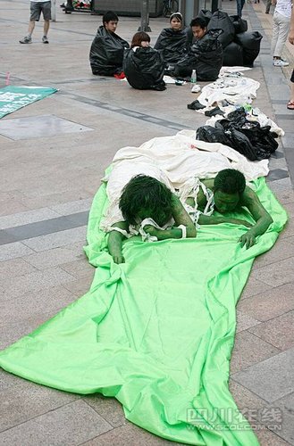 成都大学生为宣传环保 穿着垃圾袋趴在大街上