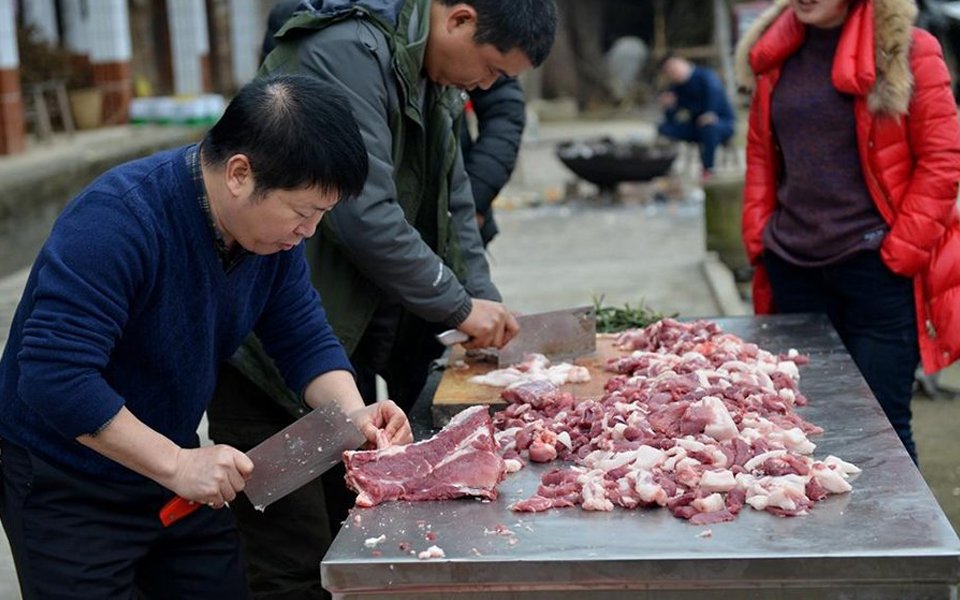 将猪肉放在案板上,杀猪匠要用刀切割成一块一块,才能宣告一条猪宰杀