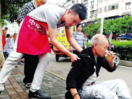 小伙子伸手帮忙扶起老人