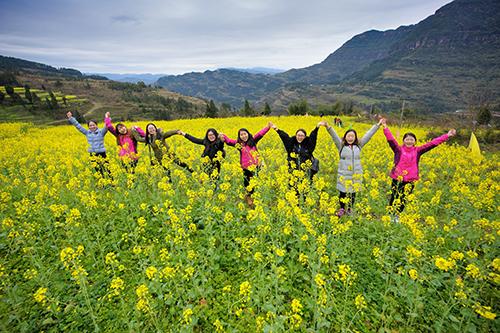 3月15日,綦江区石角镇千秋村,游客在油菜花丛中拍照留念.