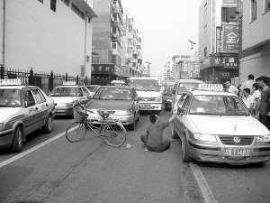 残疾男子坐马路中央设卡收费 每车一毛钱(图)