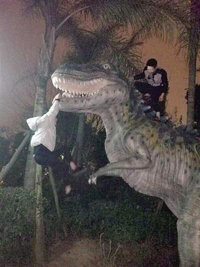 恐龙谷雕像磨损严重 经常有游客攀爬留影
