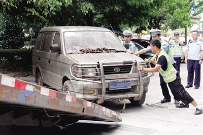 执法人员将“僵尸车”拖走。