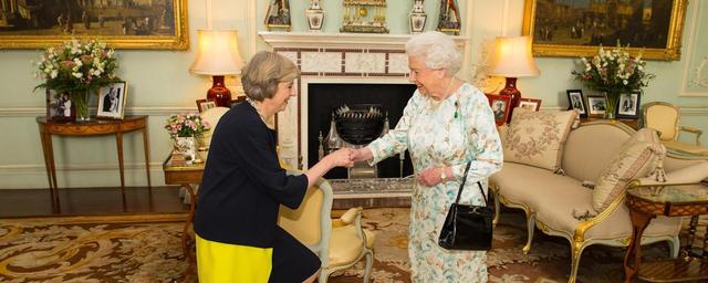 照片中,英国新任首相特雷莎·梅(theresa may)正向英国女王屈膝行礼