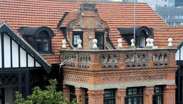 大宅屋顶的巴洛克风格装饰和两侧的老虎窗，屋顶上已无壁炉烟囱